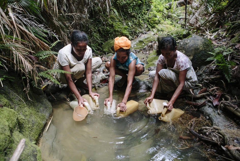 ladies fetching water from stream